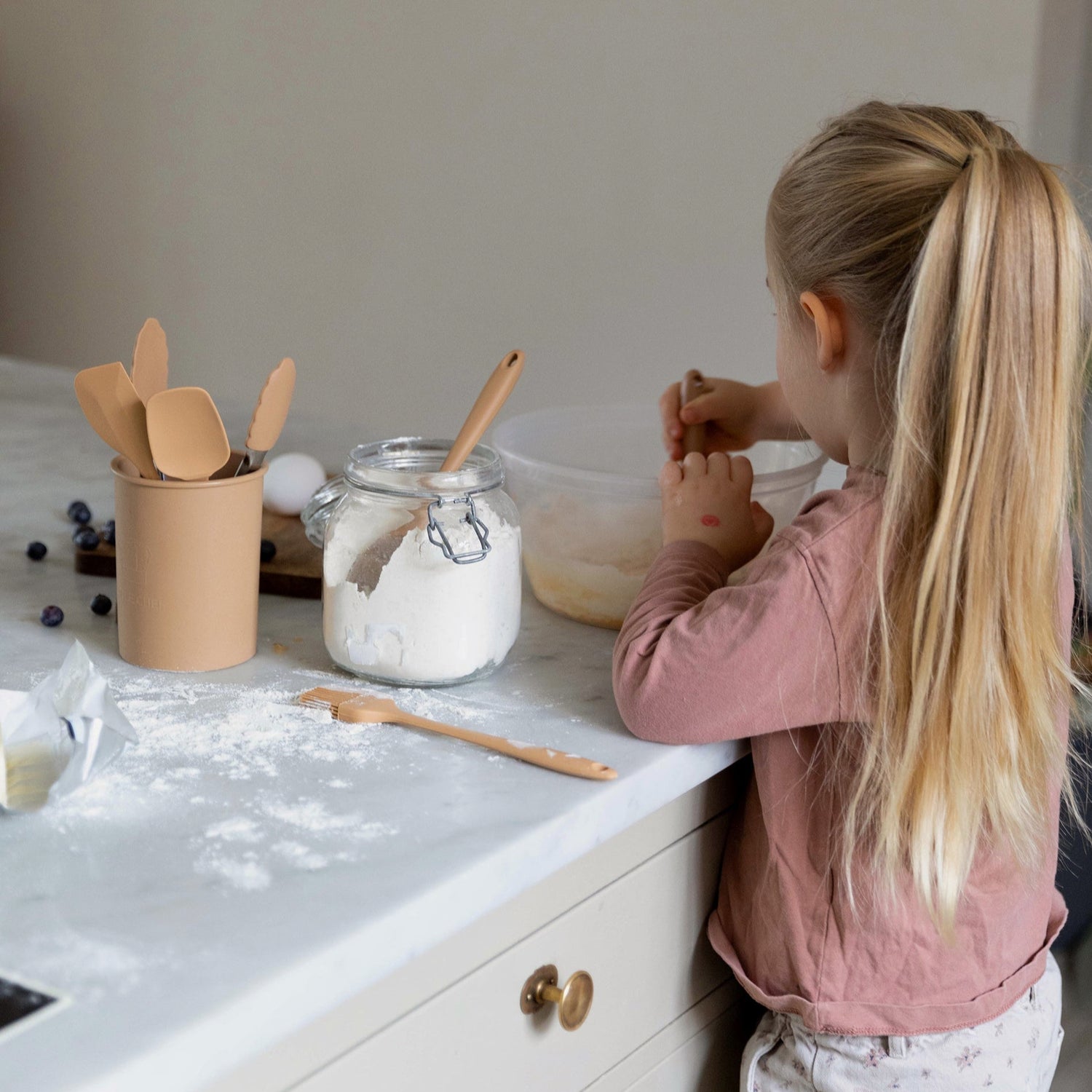 Et barn bager i køkkenet med køkkenredskaber til børn fra danske børnemærke Everleigh and me.