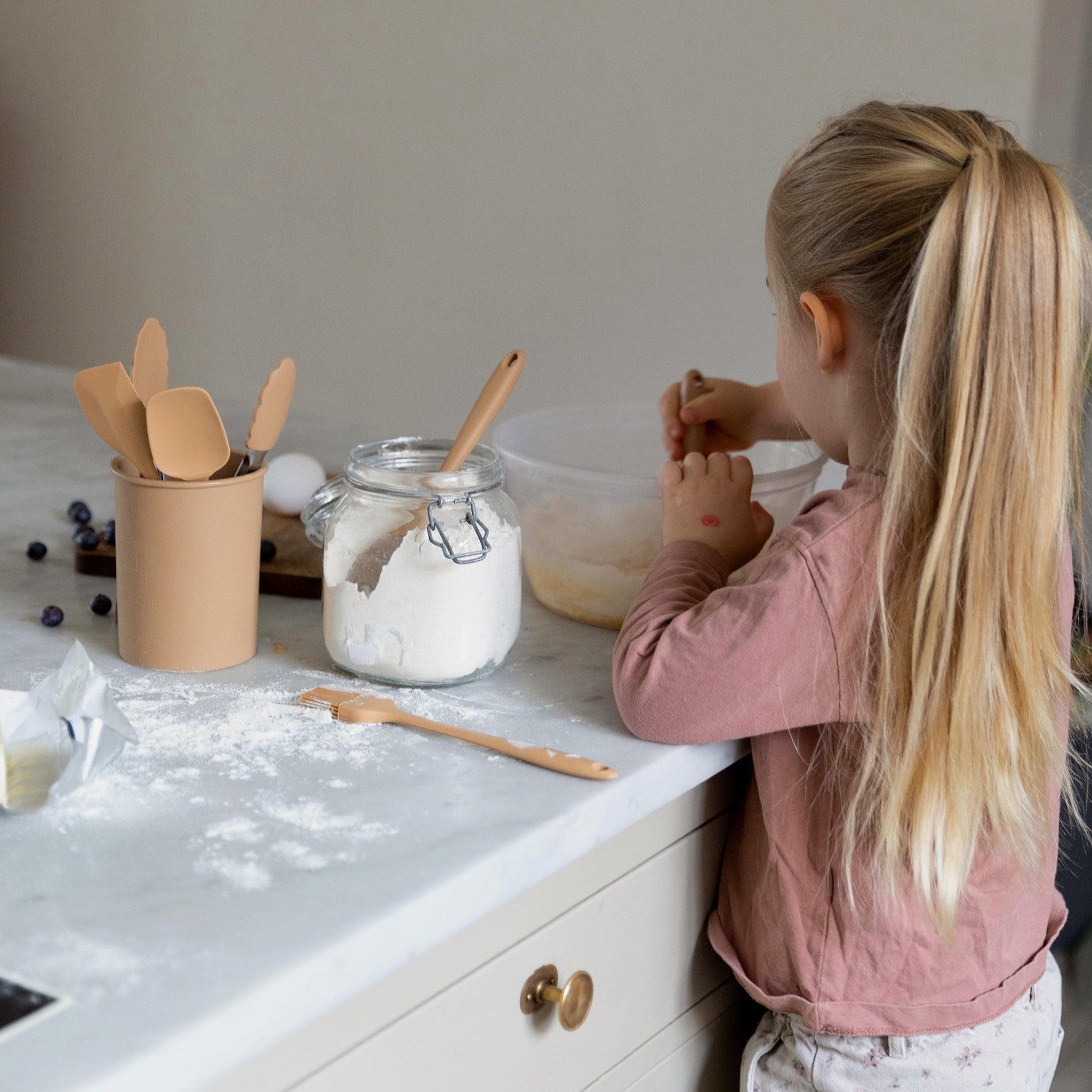 Et barn bager i køkkenet med køkkenredskaber til børn fra danske børnemærke Everleigh and me.